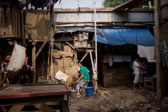 Pumping water outside their semi permanent house under a bridge ciliwung06.jpg